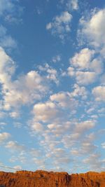 Low angle view of landscape against blue sky