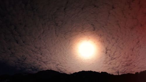 Close-up of illuminated sun against sky during sunset