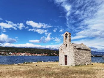 Historic building by sea against sky