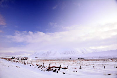 Scenic view of snow covered land against sky