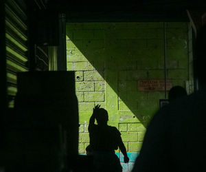 Low section of silhouette woman with shadow on tiled floor
