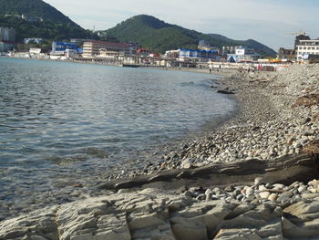 Scenic view of sea by buildings against sky