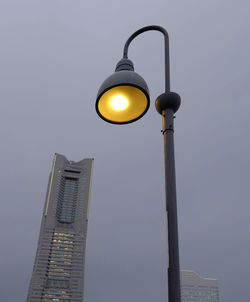 Low angle view of illuminated street light against sky