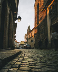 People walking on street amidst buildings in city