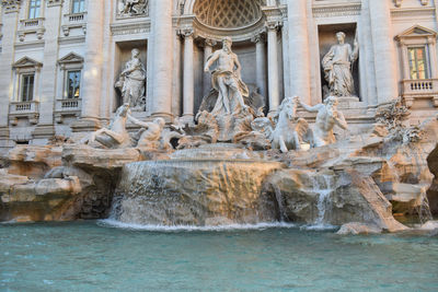 Statue of fountain in front of historical building