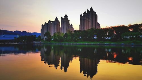 Reflection of buildings in lake at sunset