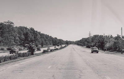 Cars on road against sky in city