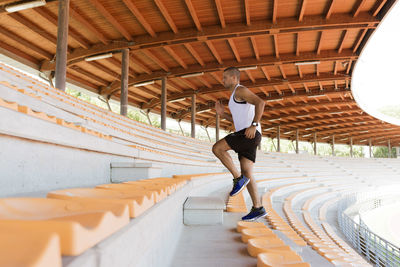 Young sportsman running over seats