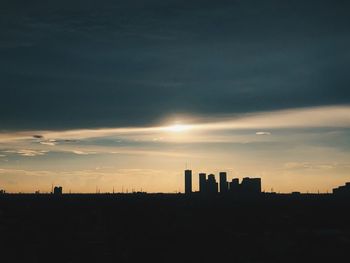 Silhouette buildings against sky during sunset