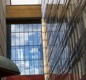 Low angle view of glass building against sky