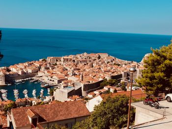 High angle view of town by sea against clear sky