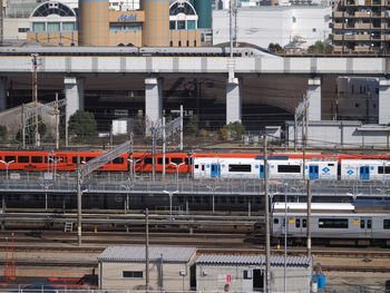 Train on railroad tracks by buildings in city