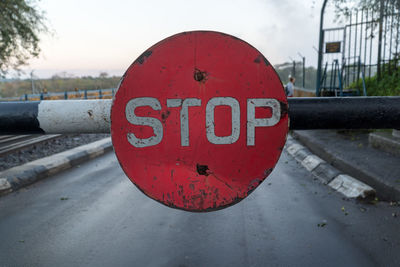 Close-up of stop sign on road against sky