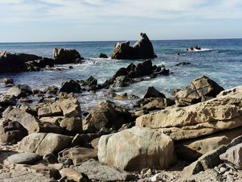 Scenic view of rocks in sea against sky