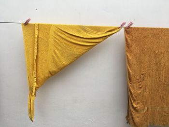 Close-up of towels drying on clothesline against wall