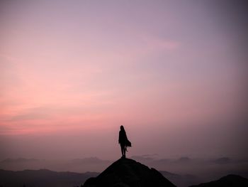 Silhouette woman standing on top of mountain against sky