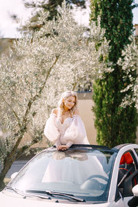 Bride standing in car outdoors