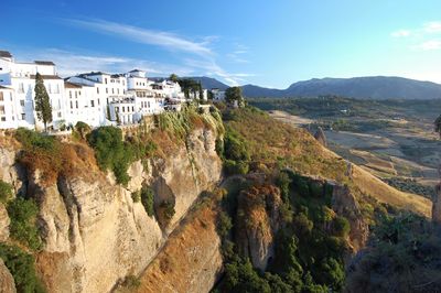 Houses on cliff against sky