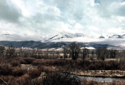 Snow covered mountains against cloudy sky