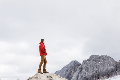 Full length of man standing on rock against sky