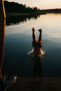 Shirtless man diving into lake