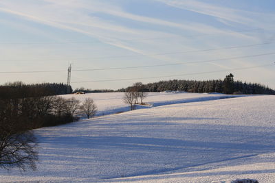 Scenic view of snowcapped field against sky