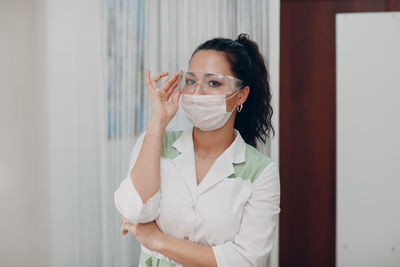Portrait of beautiful woman wearing mask at home