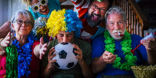 Portrait of smiling friends playing soccer at home