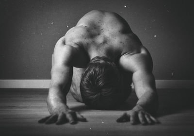 Shirtless man exercising on floor