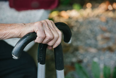 Midsection of person holding walking canes