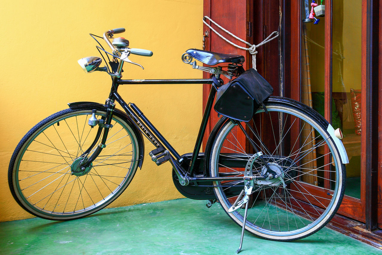 BICYCLE PARKED BY WALL