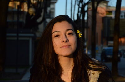 Portrait of smiling woman wearing flowers standing in city