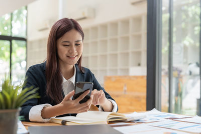Young woman using mobile phone at office