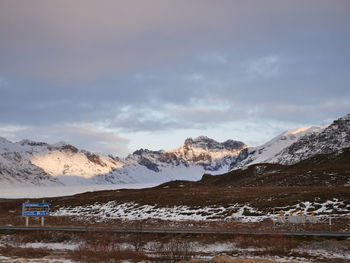 Scenic view of snowcapped mountains against cloudy sky