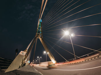 Low angle view of illuminated bridge against sky at night