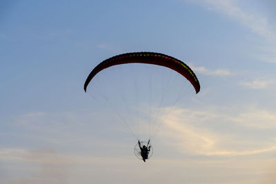 Low angle view of person paragliding against sky