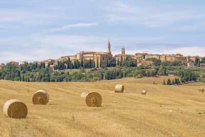 Hay bales on field against sky