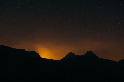 Scenic view of silhouette mountain against sky at night