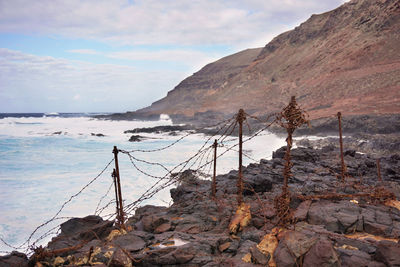 Scenic view of sea and mountains against sky