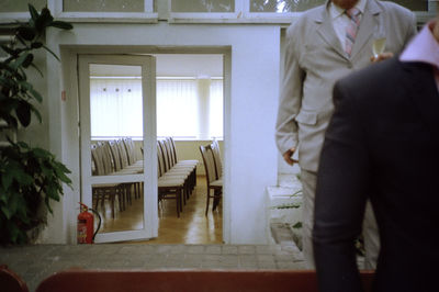 Rear view of man and woman standing at entrance of building