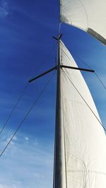 Low angle view of sailboat against blue sky