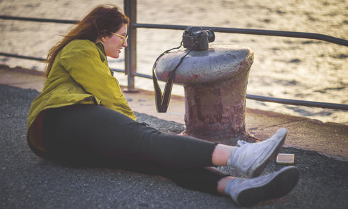 Side view of woman sitting outdoors