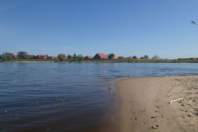 Scenic view of beach against clear blue sky