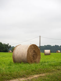 Hay bales on field against sky