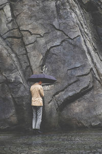 Rear view of man standing on rock