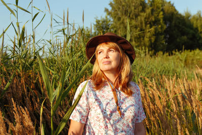 Blonde middle-aged woman near reed and pampas grass. 40s woman on nature. mental health, peaceful.