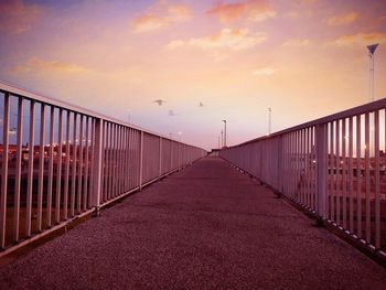 Empty bridge against sky during sunset