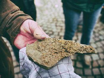 Close-up of man holding fossil outdoors