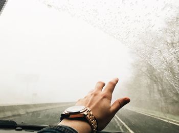 Cropped image of hand in car