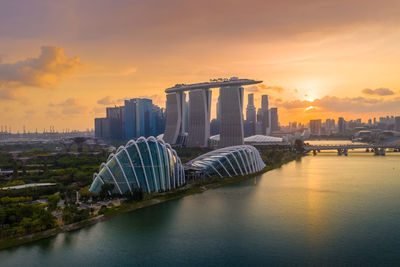 Bridge over river with buildings in background at sunset